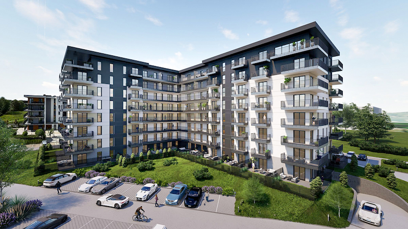 Widok nowoczesnego osiedla mieszkaniowego Podhalanin w&nbsp;Wadowicach z&nbsp;nowymi apartamentami, zielonym terenem rekreacyjnym i&nbsp;miejscami parkingowymi.